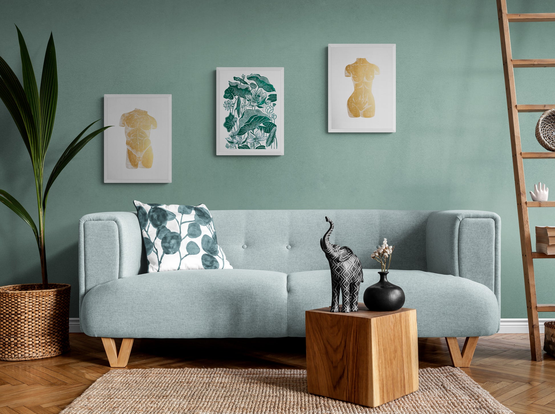 Gallery wall set of 3 linocut prints with gold busts man and woman and green lotus in living room